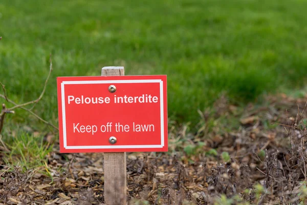 Firma en francés "Keep off the lawn", en un parque — Foto de Stock